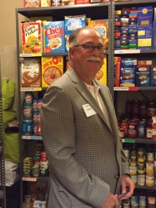 Allan M. Blum, President of the Board of Trustees of the Mid-Island Y JCC, near the JCF Food Pantry plaque.